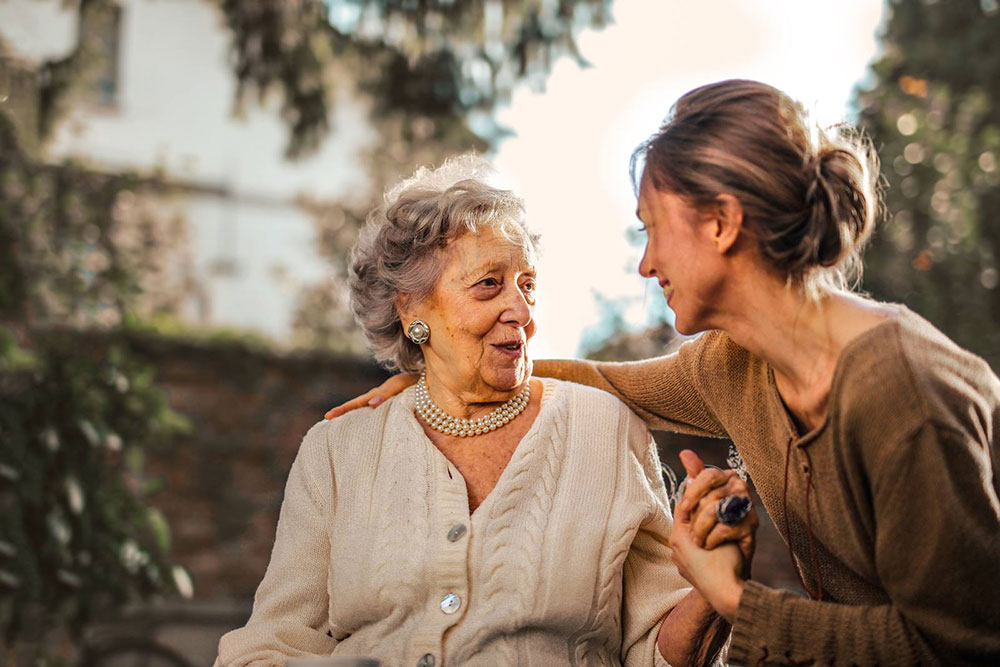 Adult daughter reassuring her hesitant elderly mother about moving to a retirement village