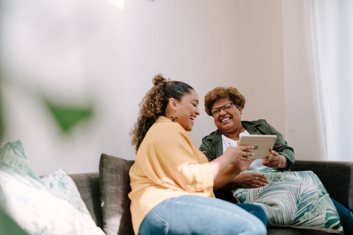 Adult daughter and her elderly mother looking at retirement village information together